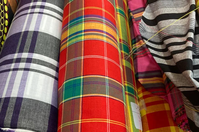 Rolls of colourful Madras fabric; illustrative textiles, not products confirmed for Fashion Source