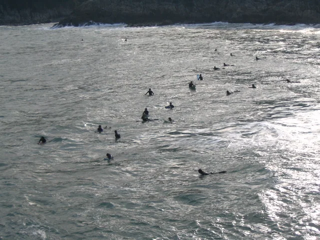 Surfistas esperando sobre sus tablas en Big Wave Bay, en la isla de Hong Kong