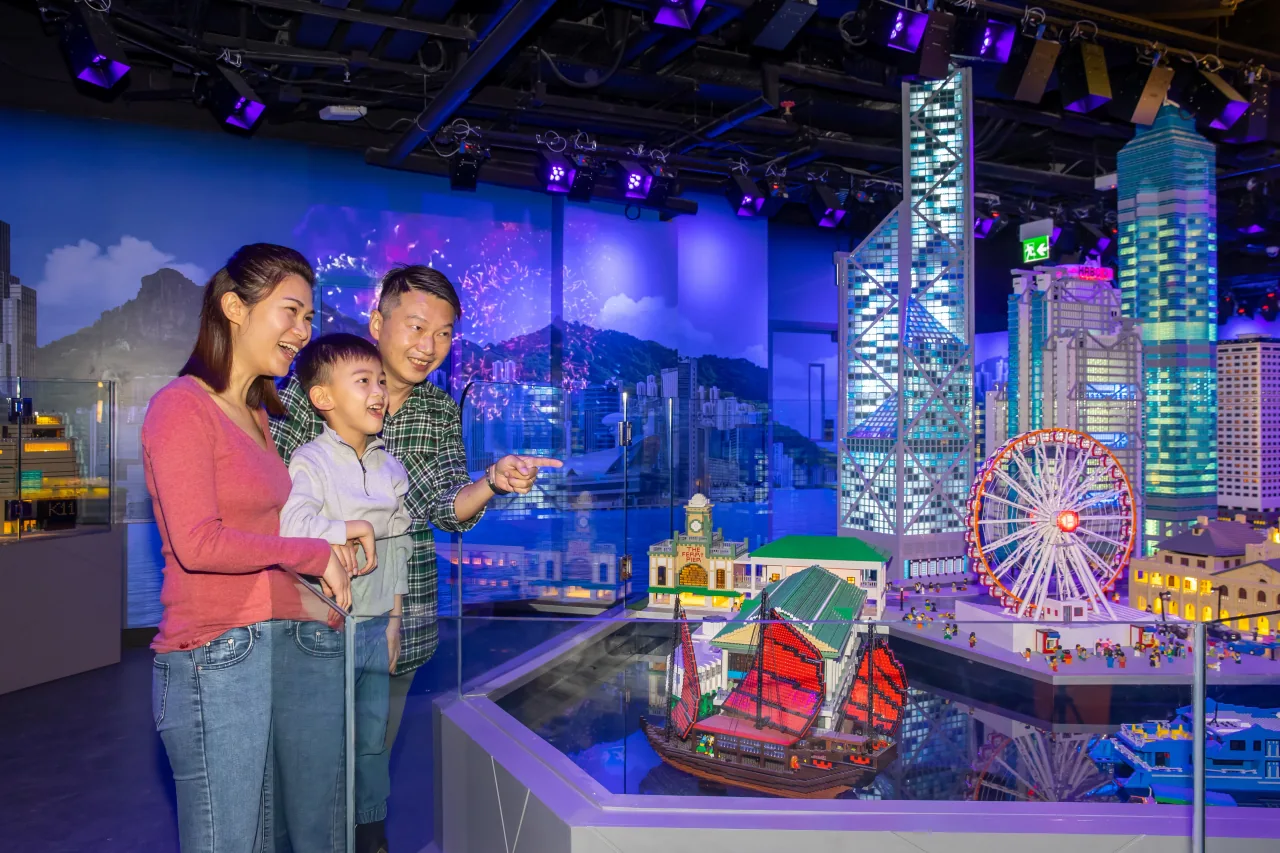 Una familia contemplando las maquetas LEGO del puerto y los rascacielos de Hong Kong en MINILAND
