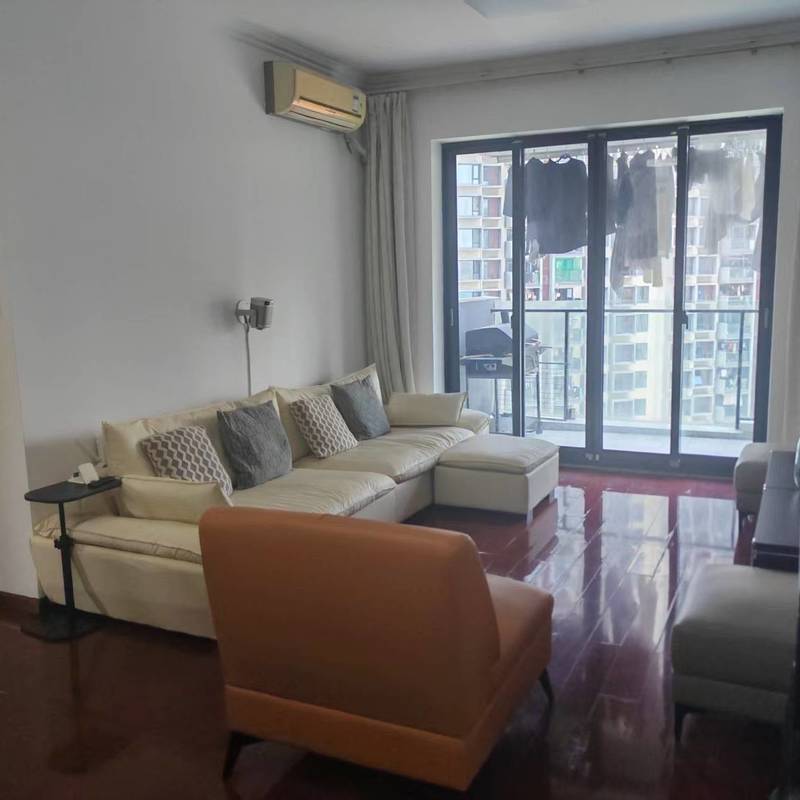 Living room with a beige corner sofa and balcony doors in the Peninsula Phase II advertiser's gallery