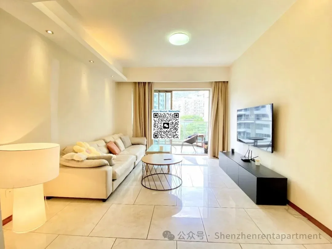 Bright living room with a pale sofa and wall-mounted television in the Mont Orchid 3 advertiser gallery