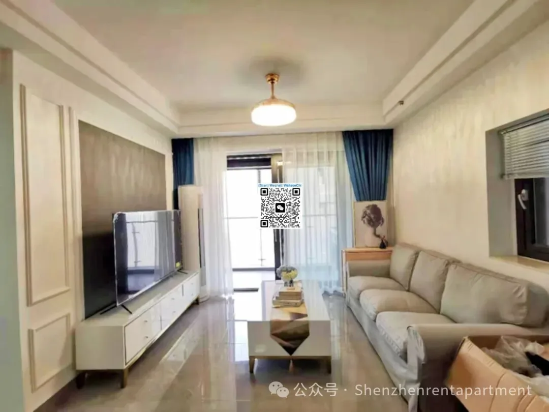 Living room with a pale sofa, television and balcony doors in the Ocean One advertiser gallery
